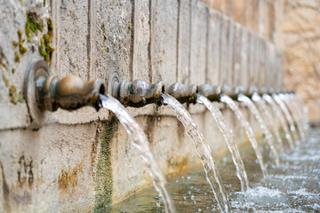 Water flowing from historical fountains in Brihuega, Guadalajara, showcasing the charm of...