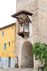 Historic architecture in Brihuega, Guadalajara showcases a charming balcony with a statue amid traditional buildings
