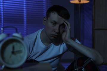 Frustrated man suffering from insomnia on floor indoors