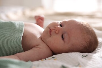 Cute newborn baby lying on bed, closeup
