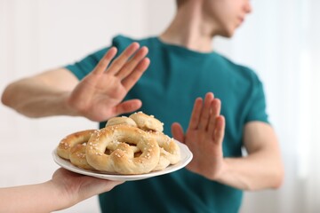 Gluten free diet. Man refusing from pastries indoors, selective focus