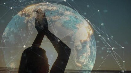 Woman stepping onto beach raising arms yoga pose rotating globe illustrating data connectivity - Powered by Adobe