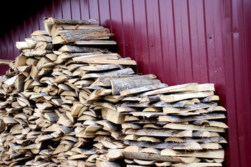 Stacked chopped firewood lies near the fence.