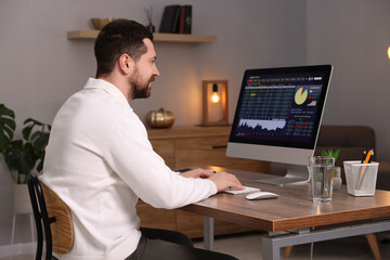 Stock exchange. Man analysing financial market on computer at desk indoors