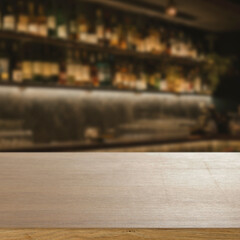 Blurred atmospheric bar with empty wooden table in the foreground, ideal for product display or...