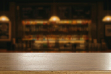 Blurred atmospheric bar with empty wooden table in the foreground, ideal for product display or...