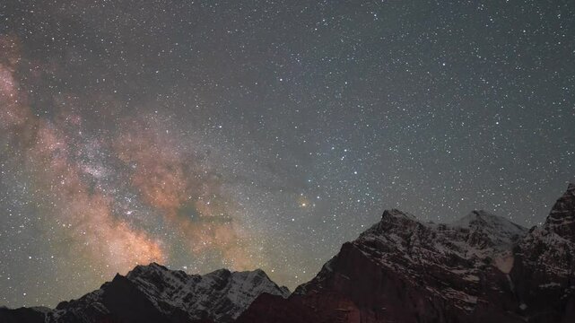 4K Zoom In Time-lapse shot of milky way above the snowy Himalayan mountain peaks during the summer season as seen from Khangsar village in Lahaul Valley, Himachal Pradesh, India. Scenic Nightscape. 