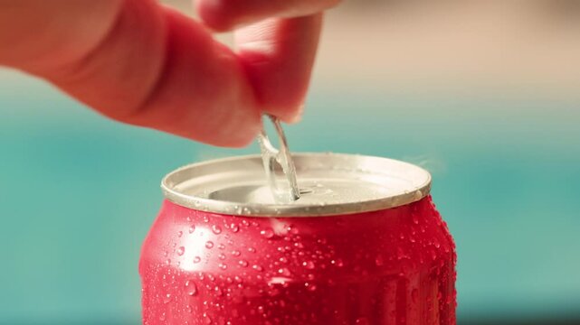 Opening soda or beer can, macro close up of can pull tab opening, watering refreshment, hand open lemonade or juice.
