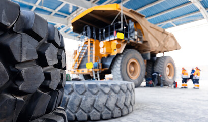 Replacing tires on wheels of mining dump car in garage. Maintenance fix service of industry truck