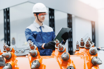 Male technician in mining industry inspecting machinery with tablet