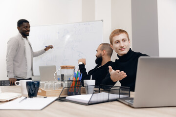 Diverse team engaged in strategic meeting, with members collaborating on project. colleague...