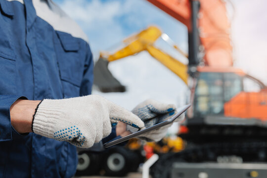 foreman industrial worker using tablet in mining excavation site