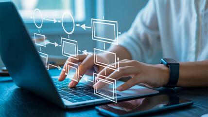 Person using a laptop with a digital flowchart overlay on a desk