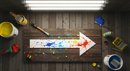 Creative Direction Colorful Splatter Arrow Sign on Rustic Wood Surface With Paint Supplies