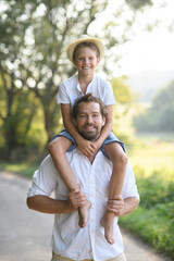 Happy father carrying son on his shoulders.