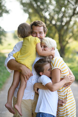 Portrait of young family with two kids hugging.