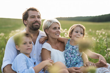 Young family enjoying peaceful summer evening outdoors in green summer nature
