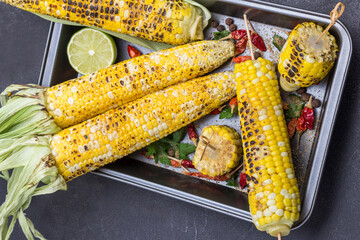 Grilled corn and dried red pepper pods on pallet