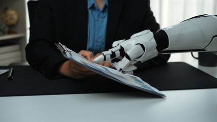 A robotic hand meticulously assists a human in an office setting, holding a clipboard filled with...