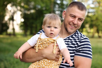 Smiling dad and his newborn baby outdoors. Happy Father's Day