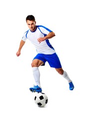 Athletic soccer player in blue and white uniform dribbling a ball isolated on white background