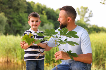 Father and his son planting tree outdoors