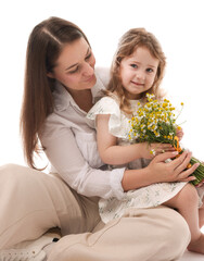 Mother and her little daughter with bouquet of beautiful chamomile flowers on white background