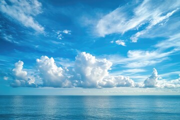 Wide ocean expanse, vibrant blue sky with fluffy clouds