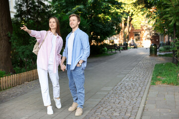 Obraz premium Lovely couple walking together on city street, space for text