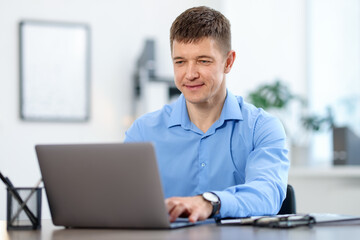 Man working on laptop at desk in office