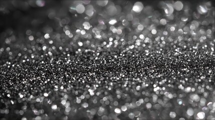 Silver glitter sparkles on a black background, creating a luxurious and festive texture, perfect for holiday decorations, invitations, or any project needing a touch of glamour