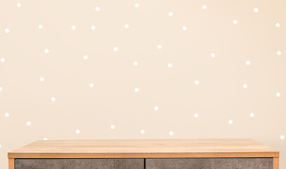 background of empty chest of drawers and beige polka dot wall