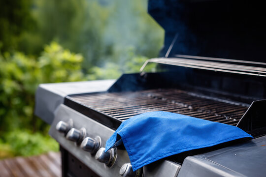 Outdoor grill ready for barbecue with a blue cleaning cloth in the backyard
