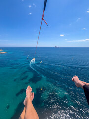 Benidorm, Spain - May 12, 2025: Midlife woman enjoying paragliding over the stunning blue waters of...