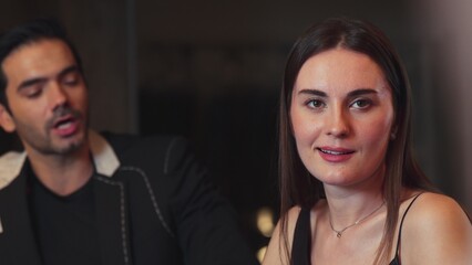 Portrait of focus beautiful woman talking with couple while looking at smartphone with serious face...