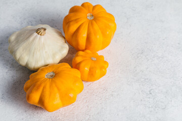Autumn composition for Thanksgiving Day with variety of pattypan squashes on white kitchen table. Flat lay, top view, copy space for text.