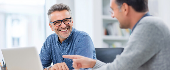 Partners in Progress: Two professionals engaged in a productive meeting, with smiles and collaboration, showing a moment of insight and shared understanding.