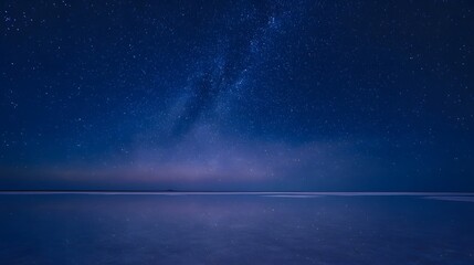 Fototapeta premium Mirror-like salt flat under a deep navy sky filled with stars and Milky Way reflection