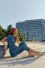 Lifestyle woman in modern boho-western denim street style wearing a red bandana, relaxed outdoors...