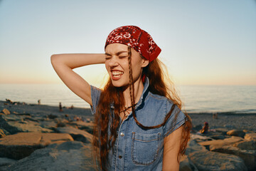 lifestyle woman in modern boho-western denim street style laughing with eyes closed near rocky...