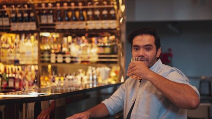 Smiling smart man drinking cocktail in Old fashioned with enjoy dancing in cheers with friends or...