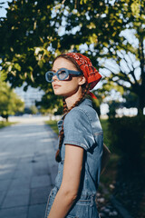 Modern boho-western denim street style woman wearing blue sunglasses and red bandana, lifestyle...