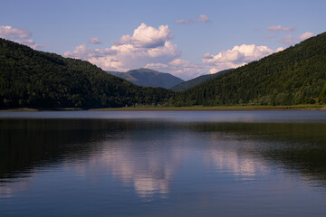 Sunset in the Mountains with Clouds and Reflection in the Lake Water