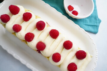 A dessert called Raspberry Tea Cake mad with a moist vanilla cake and topped with fresh raspberries or fruit and covered and filled with vanilla buttercream frosting.  Cake for a tea party.  