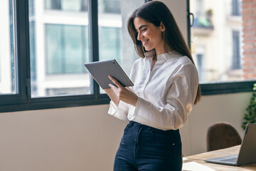 Beauty business woman using her digital tablet in a modern startup office