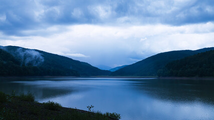 Sunset in the Mountains with Clouds and Reflection in the Lake Water