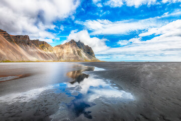 Amazing  sunny day and gorgeous reflection of Vestrahorn mountaine on Stokksnes cape in Iceland.