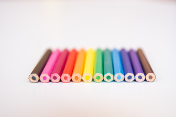 IMAGE OF COLORED PENCILS ON A WHITE TABLE
