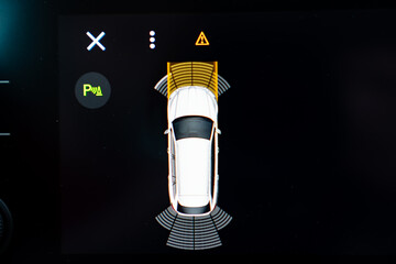 Car parking assist system display with top view of vehicle, sensor warnings, and proximity alerts on digital dashboard screen showing advanced driver assistance technology and safety feature