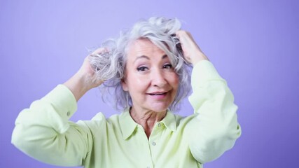 Joyful senior woman smiling and fixing her hair